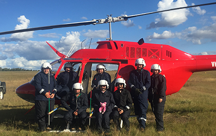 Government workers in front of a red helicopter from Biosecurity Queensland – African swine fever (ASF) prevention and preparedness project