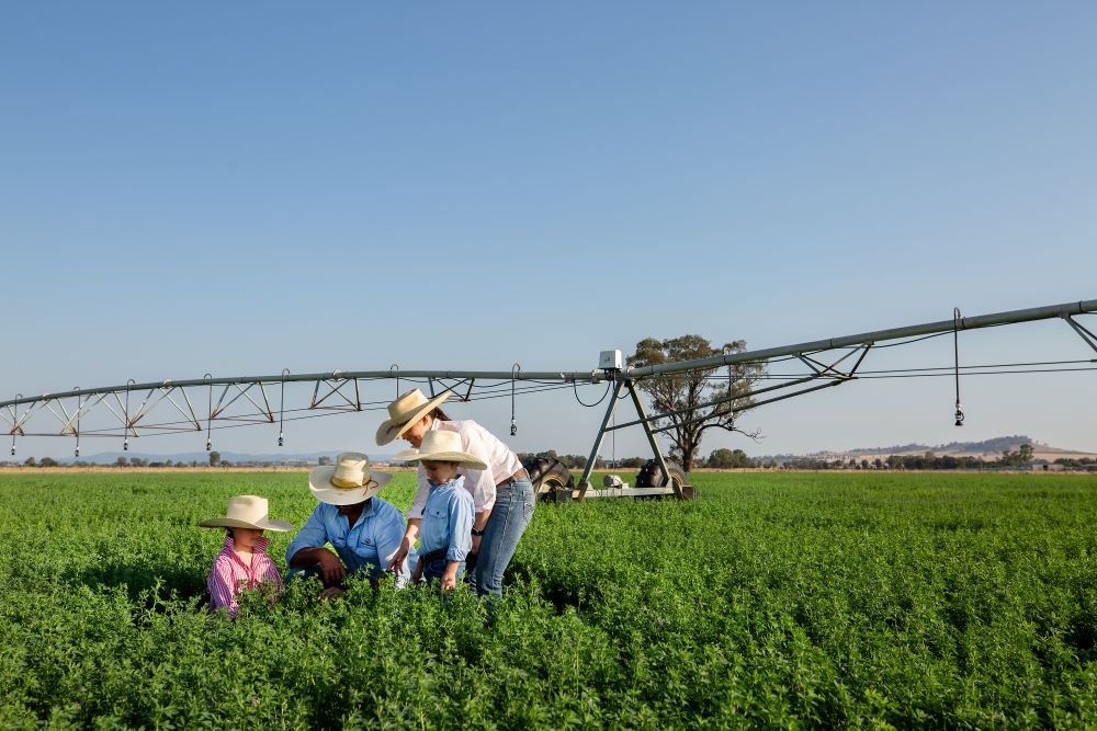 Family on farm with irrigation in background