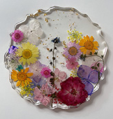 Image of beverage coaster made from flowers encased in clear resin.