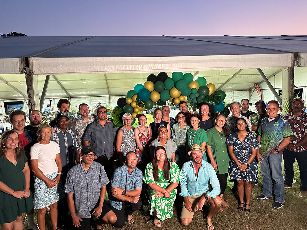 Image of a large group of people standing in front of a balloon arch; a group picture of DAFF staff at Gala Dinner event.