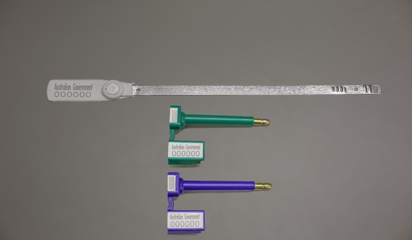 Image of three labels, one long and silver, the other two are shorter, with metal tipped plugs on one end; green and purple/blue in colour; they have "Australian Government" printed on them and the number 00000