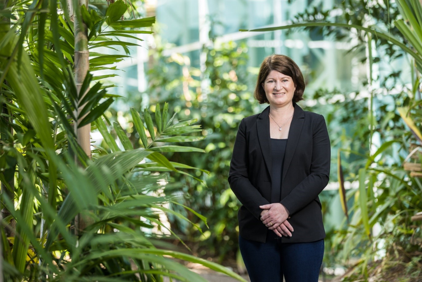 Full portrait of Beth Cookson standing among palm trees