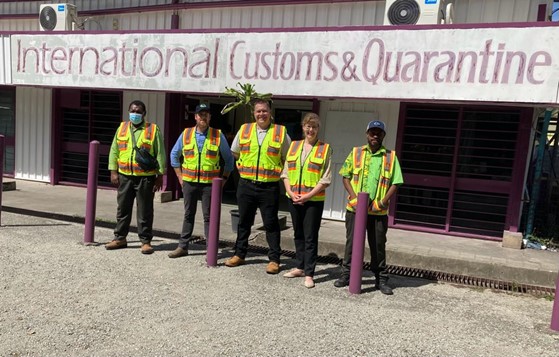 5 people in high viz stand in front of the Port Moresby cargo centre.