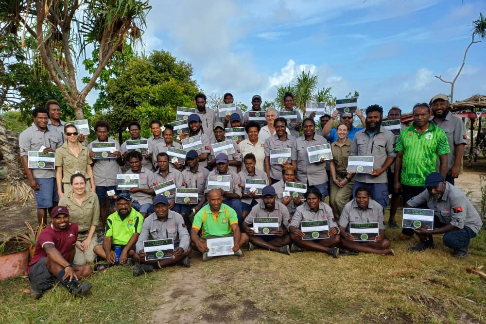 Image of a large group of people posed in rows, holding up certificates