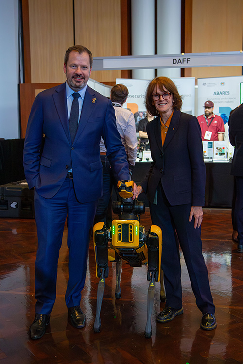 Image of two people standing next to a machine