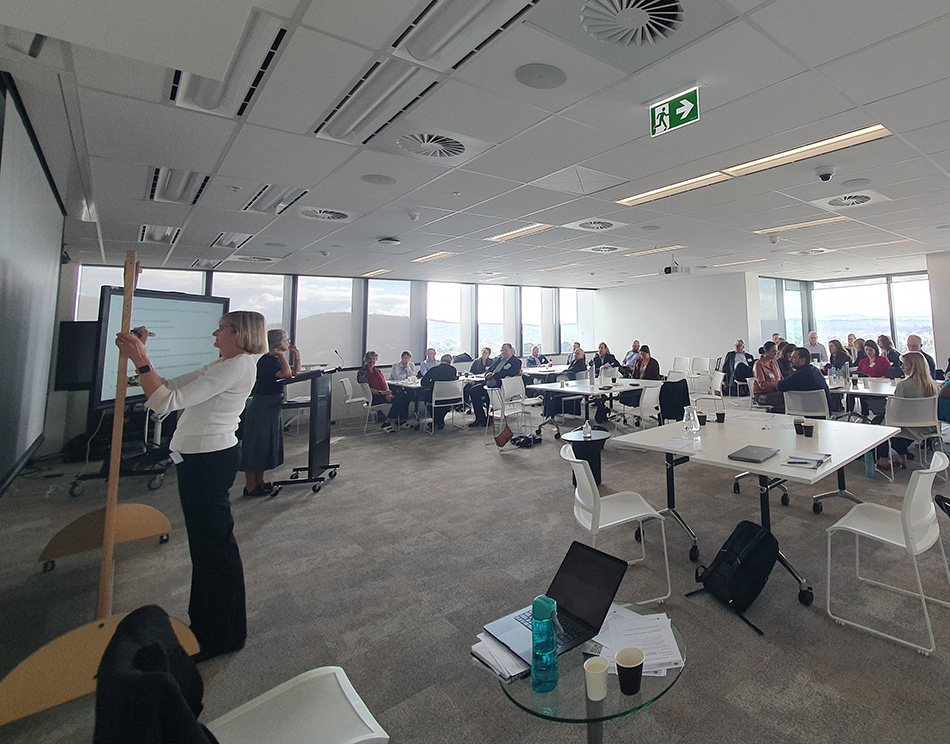 Image of a roomful of people attending a presentation