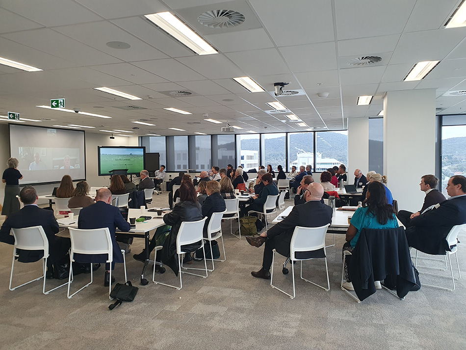 Image of a roomful of people attending a presentation