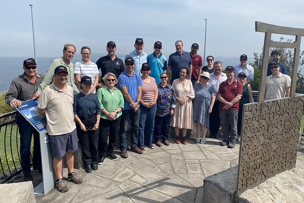 Image of a large group of people standing near a large body of water