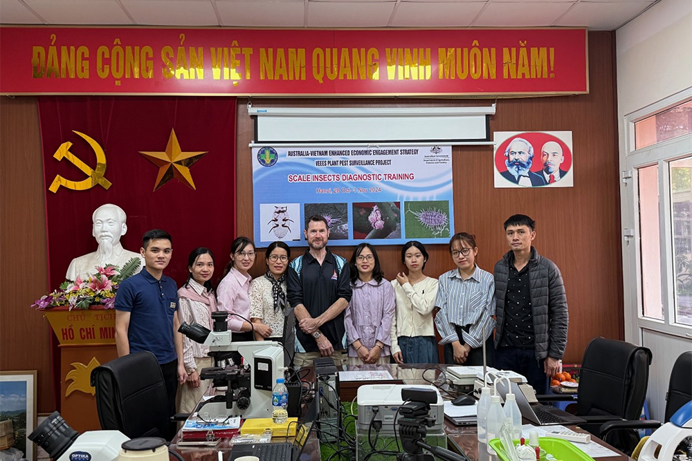 Image of a group of people standing in front of a banner on a wall