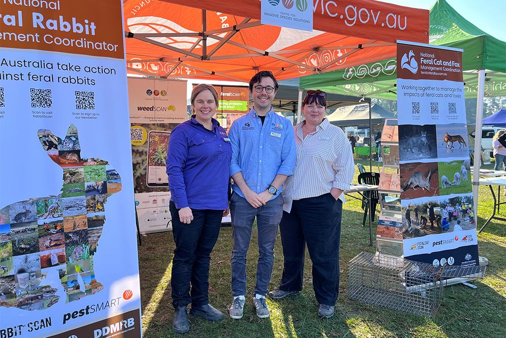 Image of three people standing in front of display posters