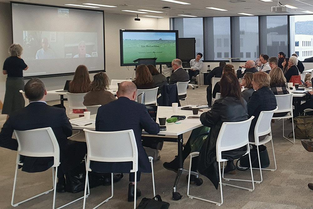 Image of a roomful of people attending a presentation